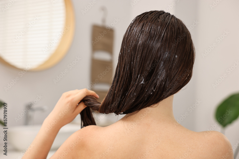 Poster Woman applying hair mask in bathroom, back view