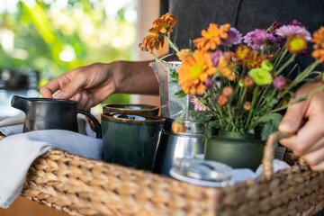 person holding breakfast trey with flowers, breakfast in bed on vacation