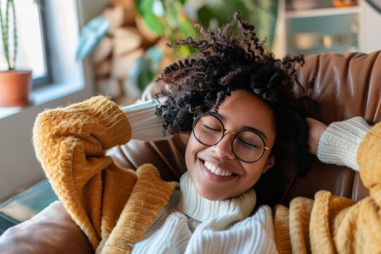 diverse woman  relaxing at home, smiling, sitting on couch listening to music