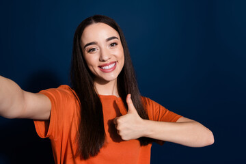 Photo of lovely cute cheerful woman wear stylish orange clothes take selfie thumb up isolated on dark blue color background