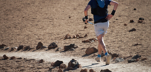 Trail running runner man on endurance run with hydratation trail vest on volcano mountain. Ultra...