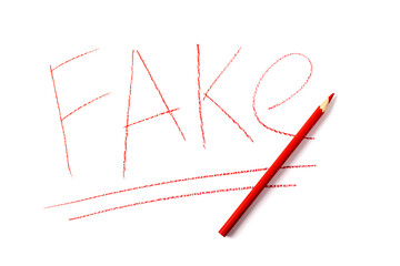 The word FAKE written in red pencil on a white sheet of paper