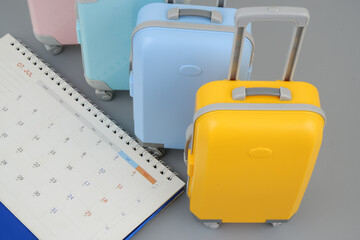 Planning travel trip and holidays and vacation concept. Many suitcases and calendar on gray...