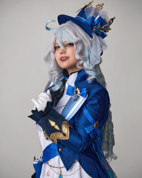 A girl in blue cosplay clothes and a wig and a crossbow poses in the studio on a light background