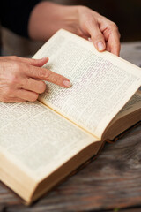 Naklejka premium Hands, person and reading bible with peace, spiritual and gratitude with faith, worship and praise. Closeup, believer and follower with holy book, guidance and personal growth with religion and home