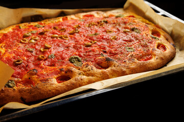 Cooking a homemade focaccia with classic tomato sauce.