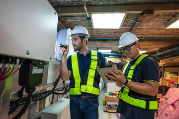 Service Engineer use tablet working inspection installation inverter solar cell. Technician...