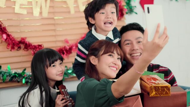 Happy Asian family spending times to prepare Chritsmas and Happy news year Celebrete. kids parent and grandparent doing ginger breads and bakery enjoy and dancing in kichen at home