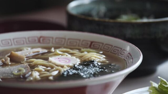 김이 모락모락 나는 토핑이 올라간 라멘 한 그릇