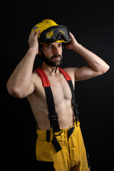Fototapeta premium Firefighter shirtless adjusting the helmet