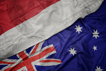 waving colorful flag of indonesia and national flag of australia on the dollar money background. finance concept.