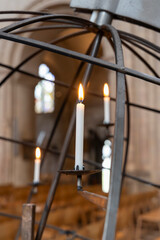 Christian votive prayer candles burning on metal globe rack in Norwich Cathedral