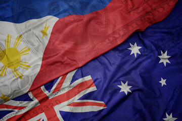 waving colorful flag of philippines and national flag of australia on the dollar money background. finance concept.