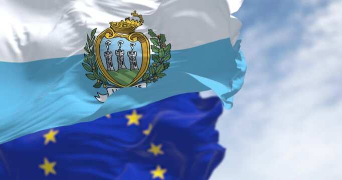 Flags of San Marino and the European Union waving on a clear day