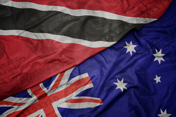 waving colorful flag of trinidad and tobago and national flag of australia on the dollar money background. finance concept.