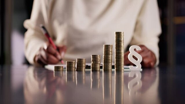 African American woman holding a white paragraph symbol and coins