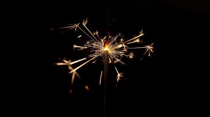 Christmas sparkler burning against dark backdrop
