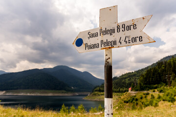 Vintage white sign by a lakeside road near Gura Apei, Retezat Mountain, Romania