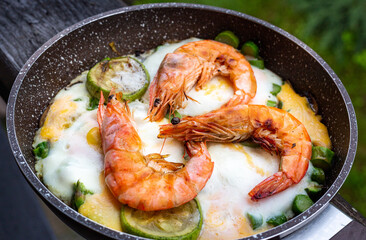 Cooking shrimp with vegetables in a frying pan.