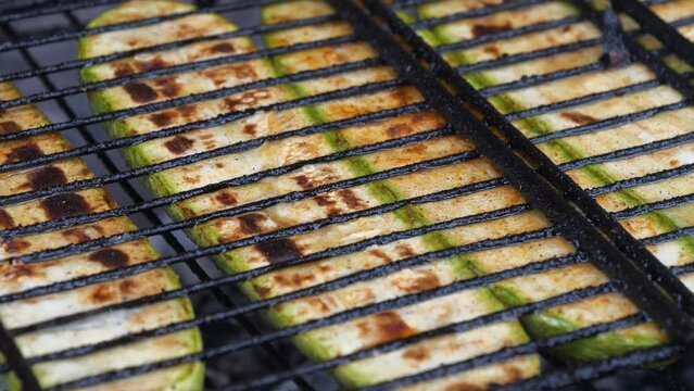 Vegetable marrow are grilled over an open fire. Zucchini was cut lengthwise broils on barbecue