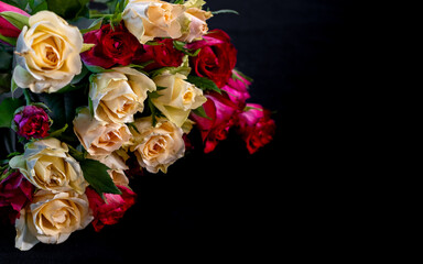 Bouquet of yellow and red roses on black background
