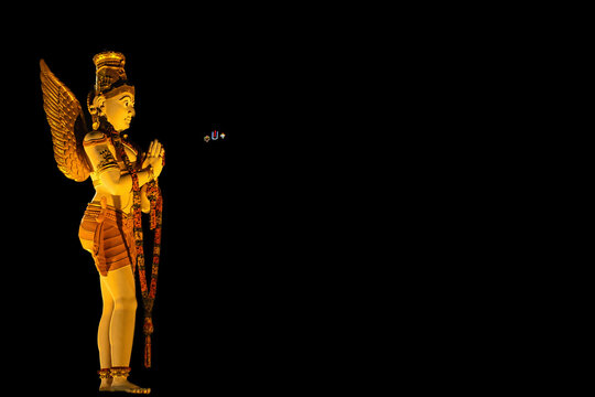 Garuda statue salutes Lord Balaji, while Thiru Namalu, shanku, chakram lighting shine on Galigopuram in Alipiri, Tirupati with space for text
