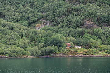 Naklejka premium Quaint, Norwegian buildings, hugging the shore of Nordfjord, one on the most spectacular fjords in Norway.
