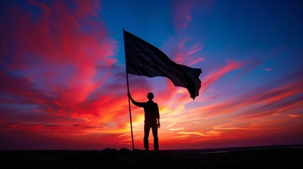 Striking silhouette of a flag bearer at twilight.