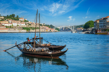 Obraz premium View of Porto city and Douro river with traditional boats with port wine barrels from famous tourist viewpoint Marginal de Gaia riverfront. Porto, Vila Nova de Gaia, Portugal