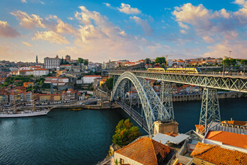 Naklejka premium View of Porto city and Douro river and Dom Luis bridge I with tram from famous tourist viewpoint Miradouro do Jardim do Morro on sunset. Porto, Vila Nova de Gaia, Portugal