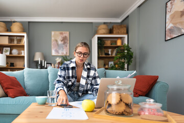 Young introvert freelancer businesswoman with ADHD working remotely from home office on laptop...
