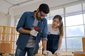 Carpenters are working at woodshop.