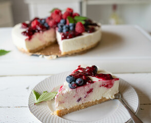 No bake cheesecake with fresh berries and berry compote on kitchen counter. Homemade summer cake