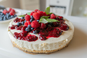 No bake cheesecake or quark cake with berry compote topping and fresh berries. Delicious summer cake