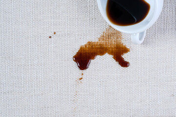 Spilled coffee. A dirty coffee or tea stain on clothes or carpet. Coffee spill ruin piece of...