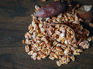 Cocoa beans and dried cocoa seed on wooden table, top view