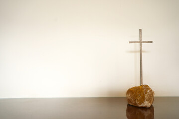 Naklejka premium Simple metal cross with wall background. Metal cross with space.