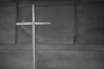 Simple metal cross with wall background. Metal cross with space.