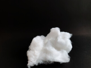 Soft white cotton wool on black background. Cotton fabric for health care in home and hospital.