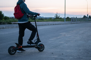 a young man on an electric scooter rides around the city © pavelkant