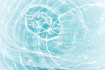 Blue water with ripples on the surface. Defocus blurred transparent blue colored clear calm water surface texture with splashes and bubbles. Water waves with shining pattern texture background.