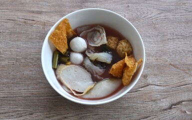 boiled fish and shrimp ball couple dumpling topping pickled cuttlefish in red soybean sauce soup on bowl