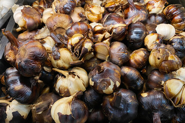 A pile of smoked garlic selling at market.