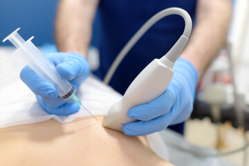 Mammalogist doctor examines woman breasts and lymph nodes during appointment. Skillful oncologist puncture of mammary glands of young patient under review ultrasound for diagnosis of breast cancer - Powered by Adobe