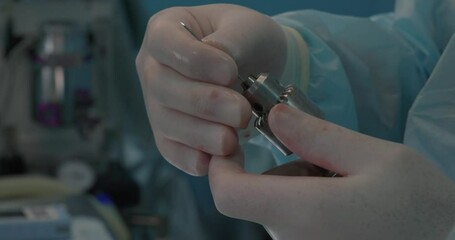 In the operating room, a veterinary surgeon inserts a wire into a drill to fix a broken bone in an animal. Close-up of a drill with a wire for performing osteosynthesis of a fracture in an animal.