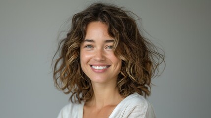 close up a smiling brunette woman with curly hair