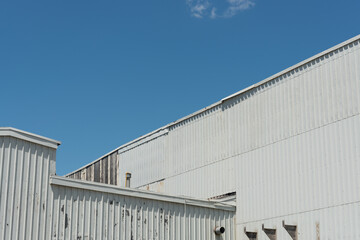 Obraz premium historic warehouse exterior wall with sheet metal cladding and blue sky