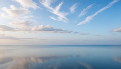Fototapeta premium A peaceful coastal background with a calm, reflective surface and a wispy, ethereal clouds