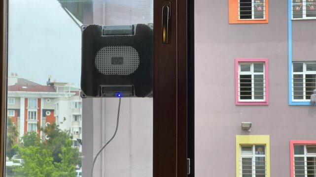 Dirty windows. Robot cleaner washes glass against the backdrop of multi storey buildings. Automatic vacuum robots for cleaning windows. Home assistant smart devices