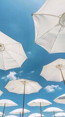 A row of white umbrellas are open in the sky, creating a sense of relaxation
